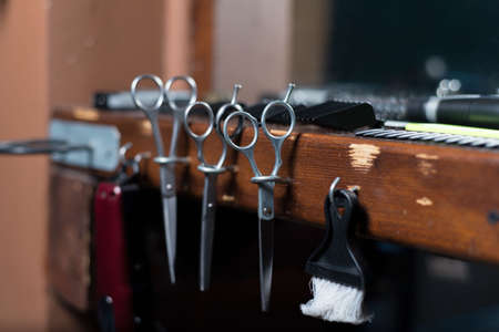 Hairdressing scissors in wooden stand hairdresser's workplace.