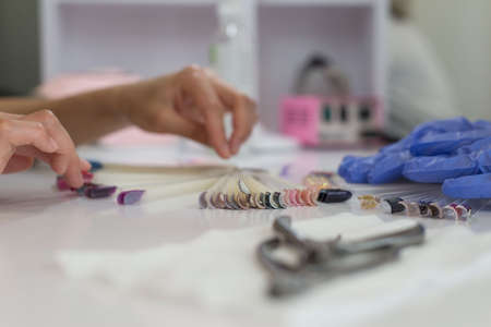 Choice of color of nails. a young girl of twenty seven years old chooses a color for nails in a...