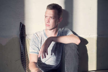 Fashionable portrait of a guy. Art photo in the style of street art in an old destroyed building. A...