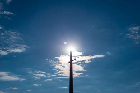 Blank Banner on Light Post lamppost against the background of the cloudy sky with the sun. Landscapeの写真素材