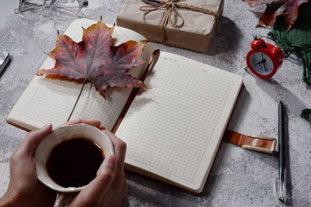 autumn flatlay top view. objects on gray-white texture. autumn leaves. holiday gift Autumn composition. Cup of coffee, blanket, autumn leaves on black background. Flat lay, top view, squareの写真素材