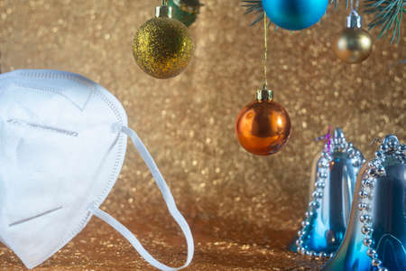 Christmas coronavirus concept, white medical respirator, near colorful christmas tree toys, self-solation.の写真素材