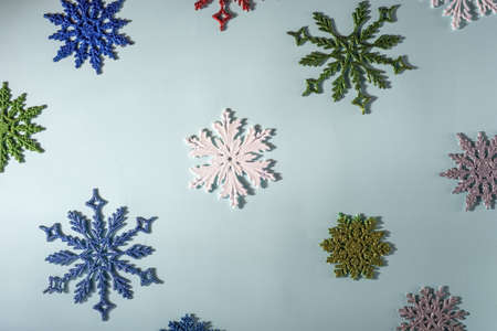 flatlay multicolored christmas snowflakes on a blue background. View from above Christmas or winter...