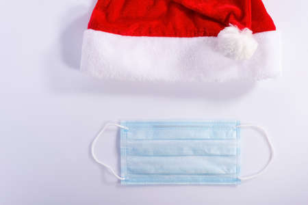 Santa hat with a protective mask on a white background, top view. christmas coronavirus concept...