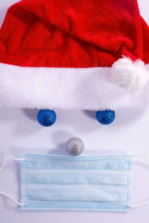 christmas santa from new year decorations with protective mask over white background Santa Claus hat and beard with face mask on a blue background, creative minimal concept of Christmas and New Yearの写真素材