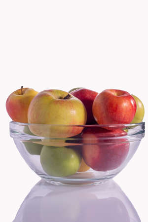 yellow and red green apples in a glass plate. isolate on white background.