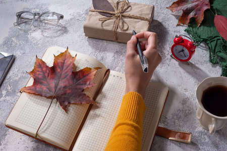 autumn flatlay top view. objects on gray-white texture. autumn leaves. holiday gift Autumn composition. Cup of coffee, blanket, autumn leaves on black background. Flat lay, top view, squareの写真素材