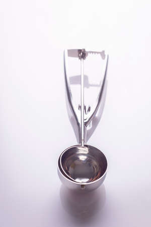 metal spoon for ice cream to form balls on a white background.の写真素材