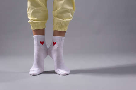 legs of a young girl with white socks with a saddle. On a gray background.の写真素材