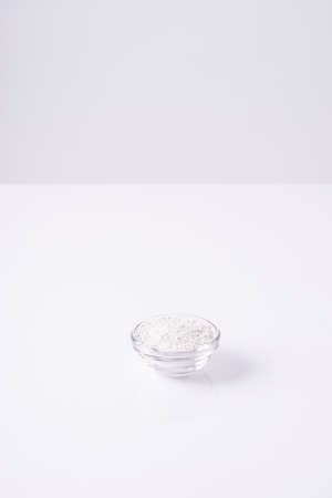 cosmetic powder for makeup and masks in a glass bowl on a white background. Minimalism advertising cosmetics.の写真素材