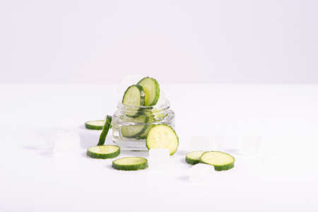 refreshing cosmetics cucumber in glass container with ice cubes on white backgroundの写真素材