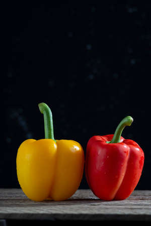 red and yellow peppers for salad, on a wooden table, in a rustic style. minimalistic conceptの写真素材