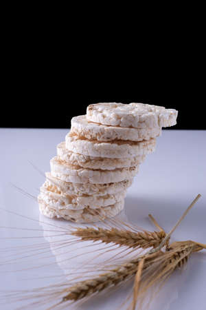 rice cakes with wheat ears on white table and black background.の写真素材