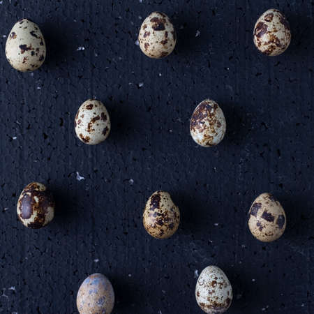 quail eggs on a black background top view.