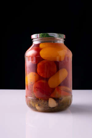 canned vegetables in a jar on a white table and black background.の写真素材