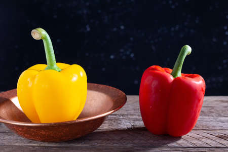 red and yellow peppers for salad, on a wooden table, in a rustic style. minimalistic concept.