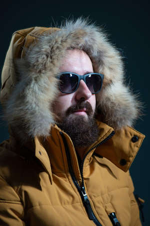 guy in a down jacket hood with fur, yellow jacket on a gray background