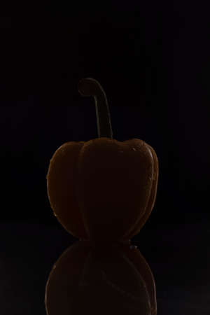 yellow pepper on a black background. Minimalistic vegetable concept.の写真素材