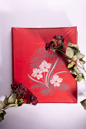 old red album with flowers on a white background.