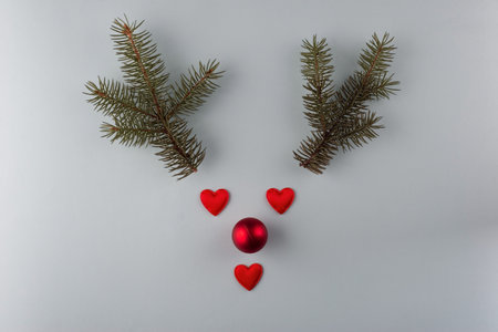 Reindeer face made of Christmas decoration and pine branches. Minimal christmas concept. Flat lay.の写真素材