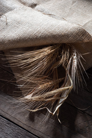 still life wheat ear in a bag on a wooden background.の写真素材
