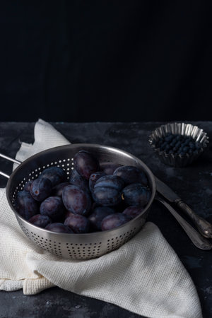 dramatic autumn still life with plums on a dark background. Rustic.の写真素材