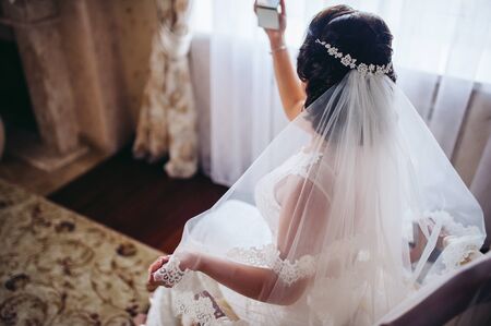 The bride looks in the mirrorの写真素材