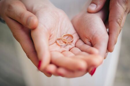 Newlyweds are holding wedding rings in handsの写真素材