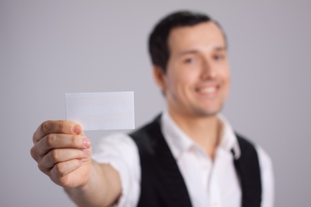 young guy with a business card in his handの写真素材