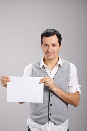 young guy with a white sheet of paperの写真素材