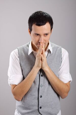 a young man with folded hands in the faceの写真素材