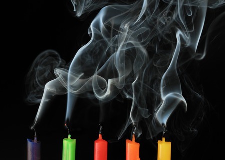 five color extinguished candles on black backgroundの写真素材