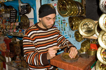 TUNIS - DECEMBER 04  An unidentified Workman pounds on a souvenir in the medina on December 04, 2009 in Tunis のeditorial素材