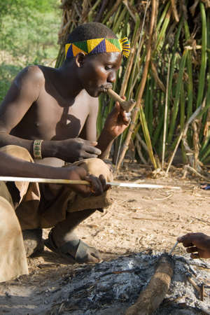 LAKE EYASI, TANZANIA - FEBRUARY 18  An unidentified man from Hadza tribe, smokes a traditional pipe, on February 18, 2013 in Tanzania  Hadzabe tribe threatened by extinction のeditorial素材