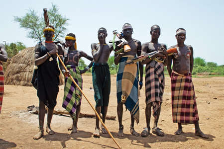 OMO VALLEY, ETHIOPIA - MARCH 13, 2010: Unidentified warrior of  the Mursi tribe with traditional ornaments protect their village in the Omo valley, Ethiopia.のeditorial素材