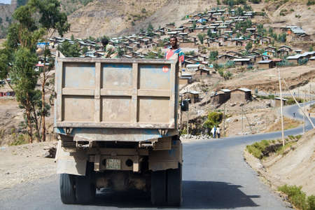 ETHIOPIAN HIGHLANDS, ETHIOPIA - FEBRUARY 21, 2010: Unidentified workers on a truck drive to a village in the Ethiopian Highlands.のeditorial素材