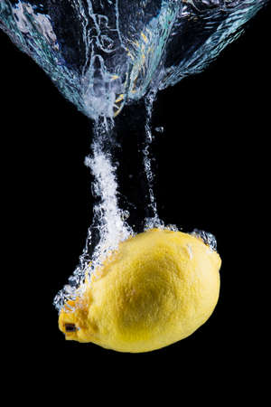 lemon underwater isolated on black background.の写真素材