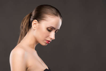 the beautiful girl naked shoulders portrait on a gray background.の写真素材