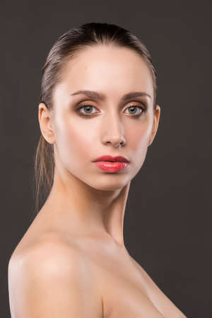the beautiful girl naked shoulders portrait on a gray background.の写真素材