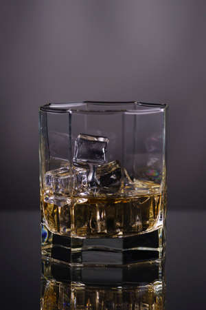 glass of whisky with ice on a grey background.の写真素材