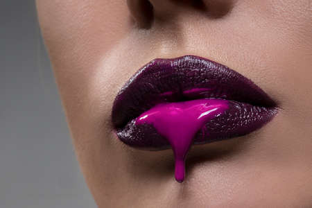 female lips with the lipstick which is flowing down from them.の写真素材