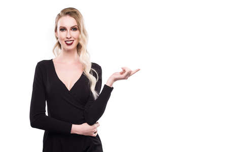 The girl points on a blank space on a white background.の写真素材