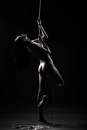 silhouette of the naked girl with the rope.の写真素材