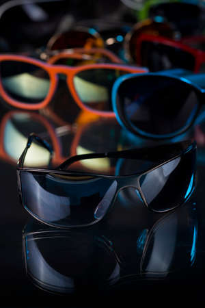 various sunglasses on a dark background.