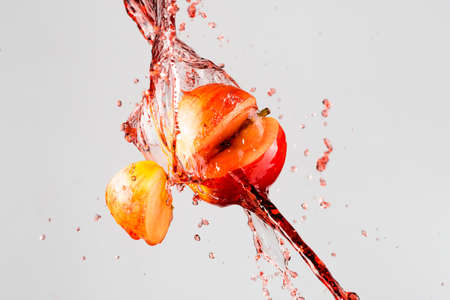 apple and red juice splash isolated on a gray background.の写真素材