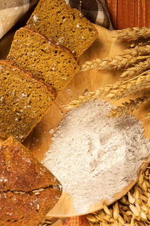 Still life with rye bread, ears of corn on the background of wooden boards