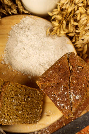Still life with rye bread, ears of corn on the background of wooden boards