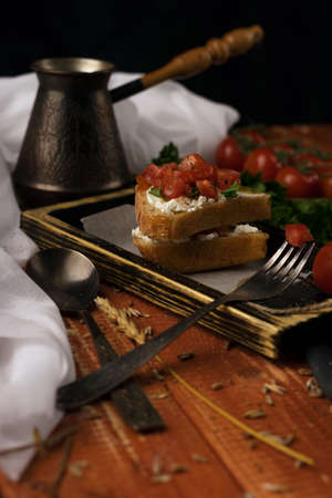 still life. Cezve, cherry tomato branch, bread, fork.