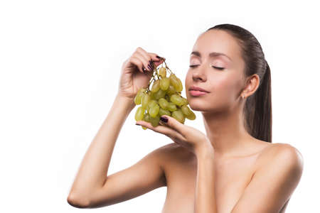 young sensual girl beauty portrait with a green grapes isolated on a white background. copy space.の写真素材