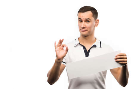 A young man holds an empty plate in his hands to fill your text. Emotional, courageous face. Isolated on white background. Copy space. Advertising, and commercial Design,の写真素材